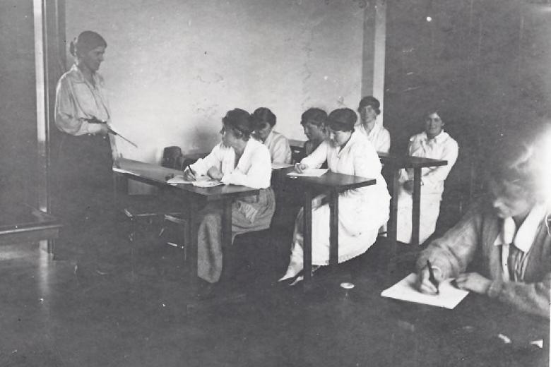 Eileen Power teaching in a classroom at Girton College taken by Bassano Ltd, 1919 (archive reference: GCPH 7/1/7)