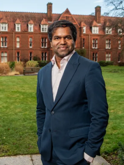 Dr Sabesan Sithamparanathan stands in front of Girton College