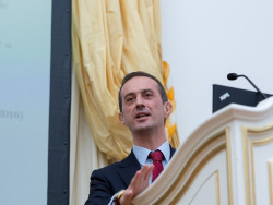 Professor Lucio Sarno stands at a lectern 