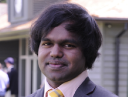 Dr Sabesan Sithamparanathan stands in front of the John Marks Sports Pavilion in the grounds of Girton College