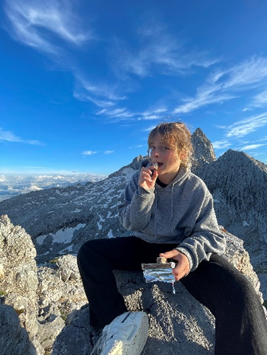 Elena sat at the top of a mountain eating