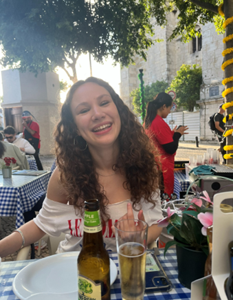 Maggie laughing at a dinner table.