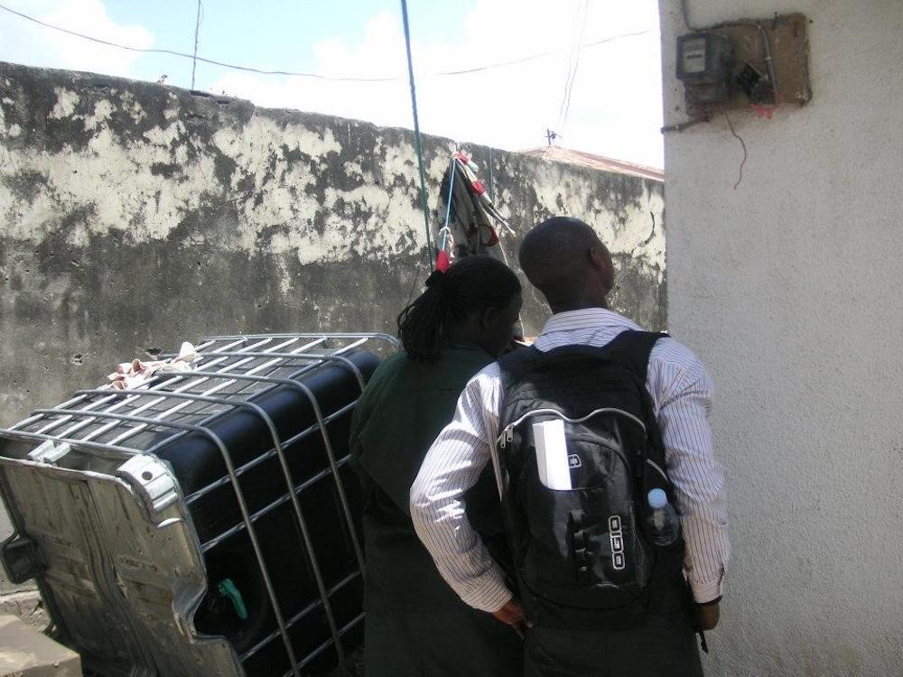 Utility inspectors gazing at a tampered electrical meter. 