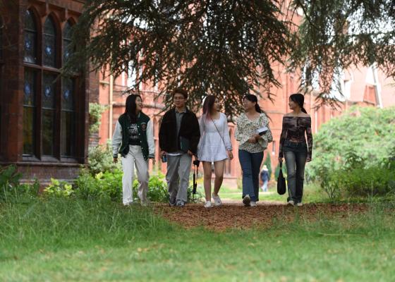 Students walking under the tree by the Stanley Library