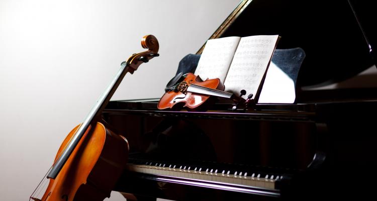 Cello and violin resting on a piano