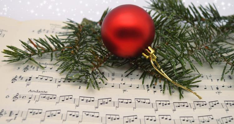 music sheet with xmas tree branch and a red bauble