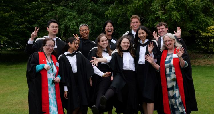 Students posing at graduation with 2 Fellows