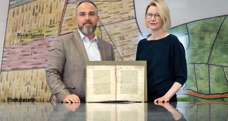 Dr Katie Walter and Dr James Wade in The Keep archive, Brighton, with the fragment of Nicholas Love’s early 15th-century Mirror of the Blessed Life of Jesus Christ. Credit: Courtesy of the University of Sussex