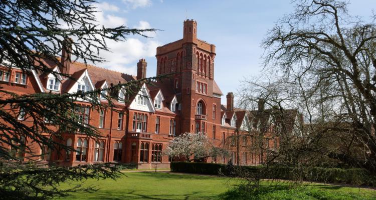 Girton College Tower in the spring sunshine with trees lining the foreground
