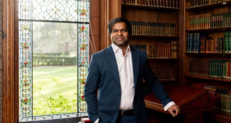 Dr Sabesan Sithamparanathan standing in the Stanley Library at Girton College