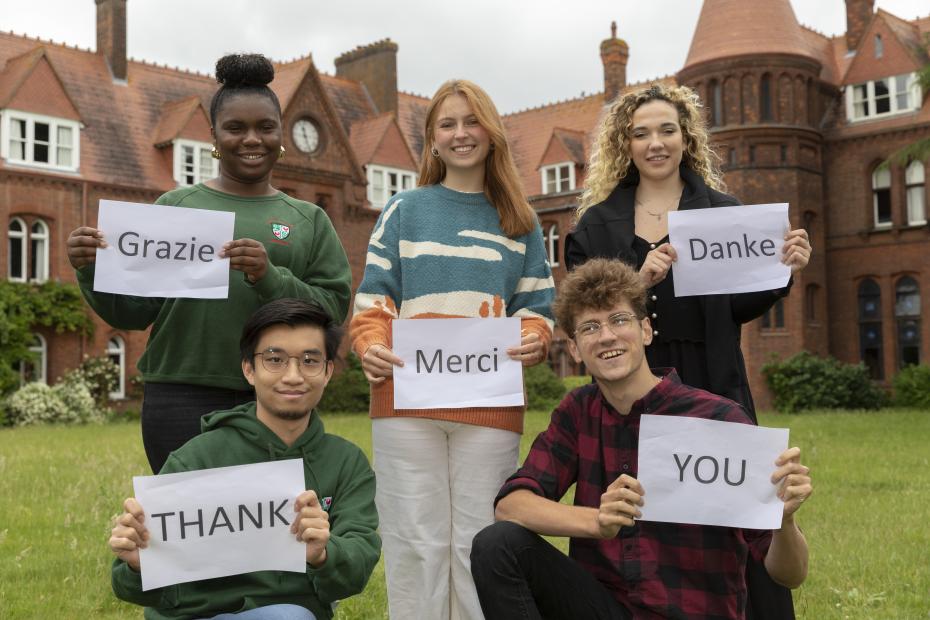 Girton students holding up signs saying thank you in different languages