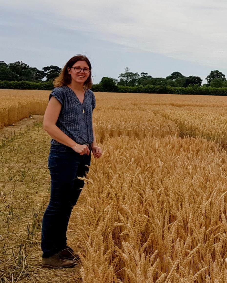 Dr Stéphanie Swarbreck standing facing opposite crops in a field