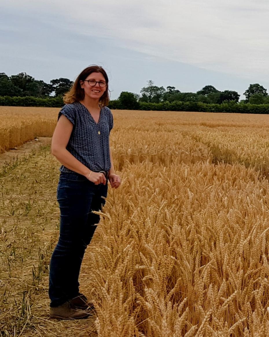 Dr Stéphanie Swarbreck standing facing opposite crops in a field