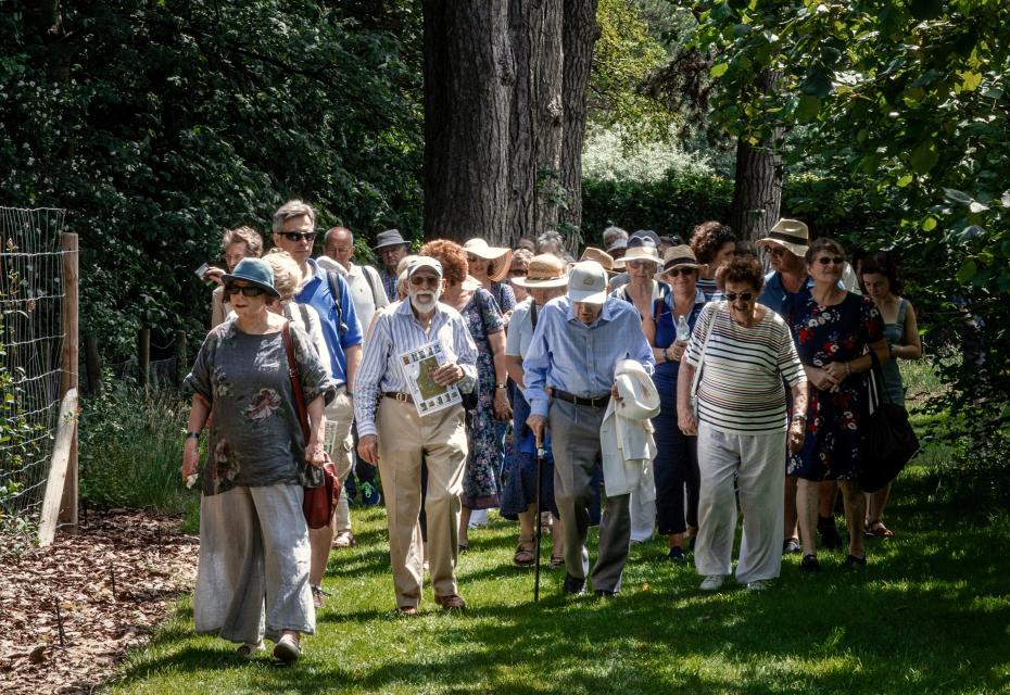 large group walking toward honey suckle walk attending the Girton150 Festival